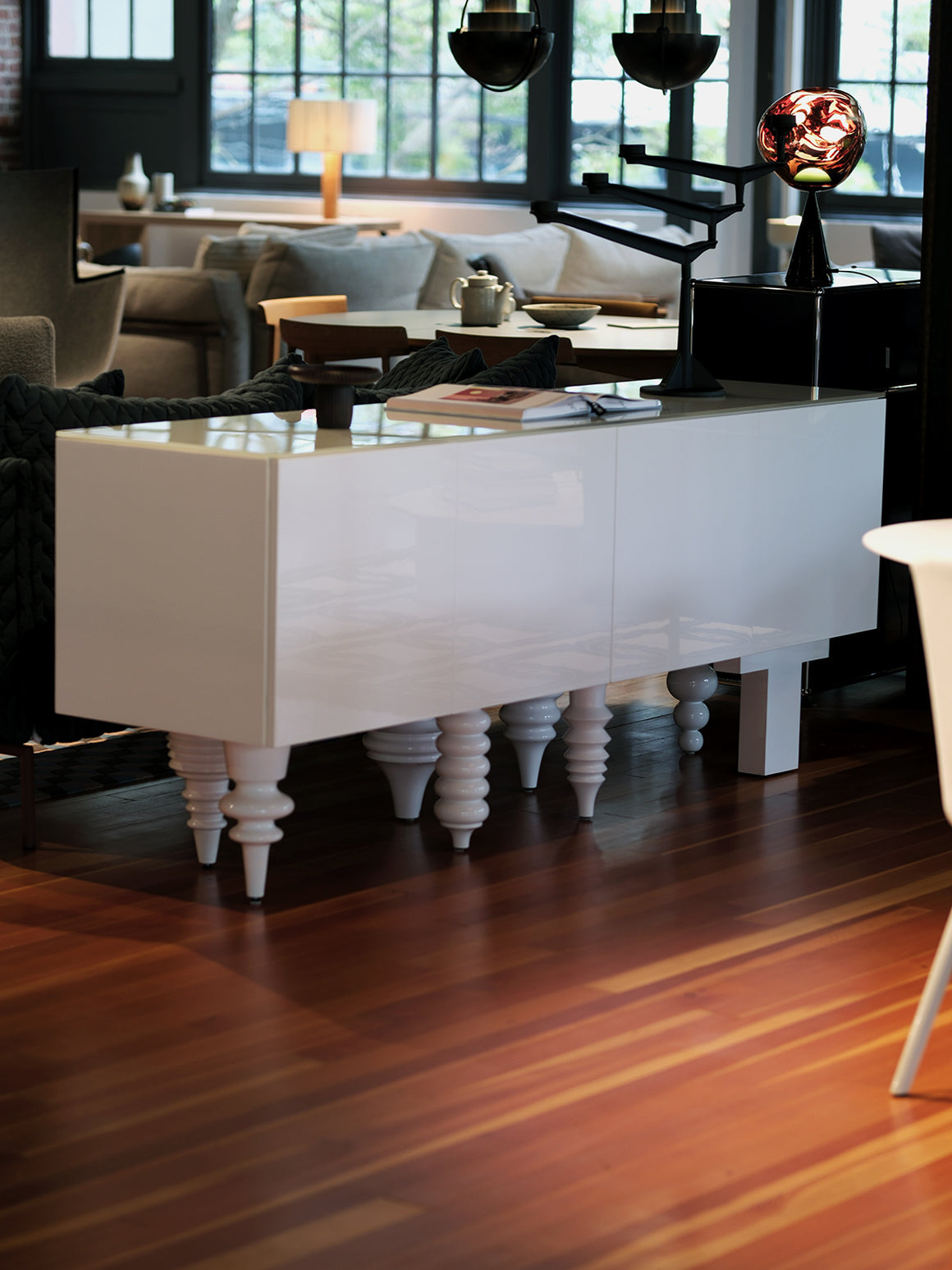 White console table with decorative items in a stylish room with wooden flooring.